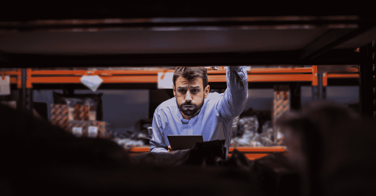 Confused supervisor leaning on storage shelf (1)