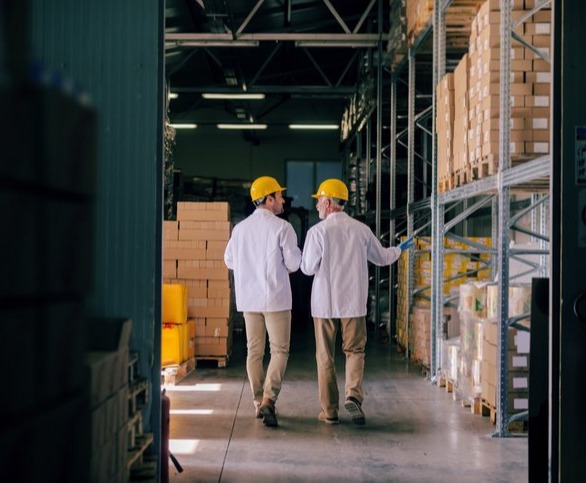 Two men walking in a warehouse: Vendor Managed Inventory benefits